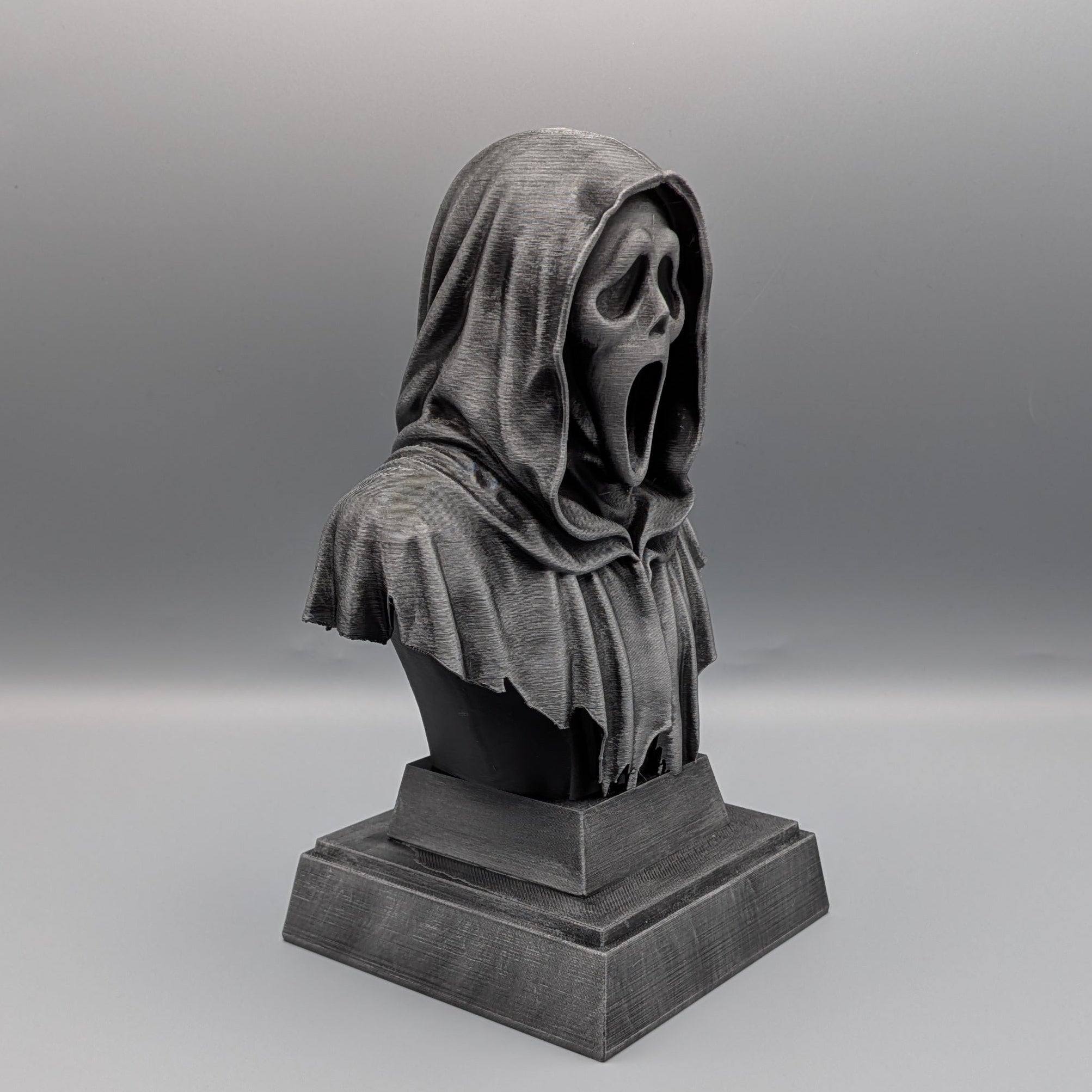 Right-hand side view of the silver Ghostface tribute bust with a flowing hood and detailed tattered robe