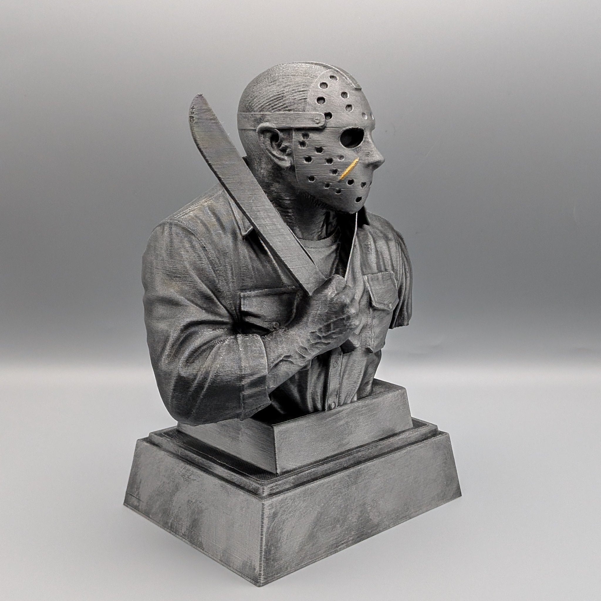 Right-hand side view of the hand-painted Jason Voorhees tribute bust holding a machete on a solid pedestal base