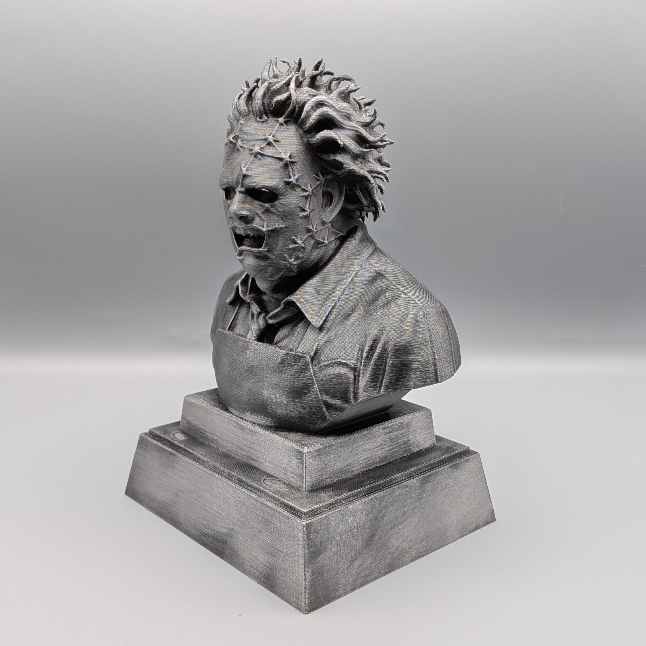 Left-hand side view of the hand-painted Leatherface tribute bust showing the stitched mask, wild hair and apron