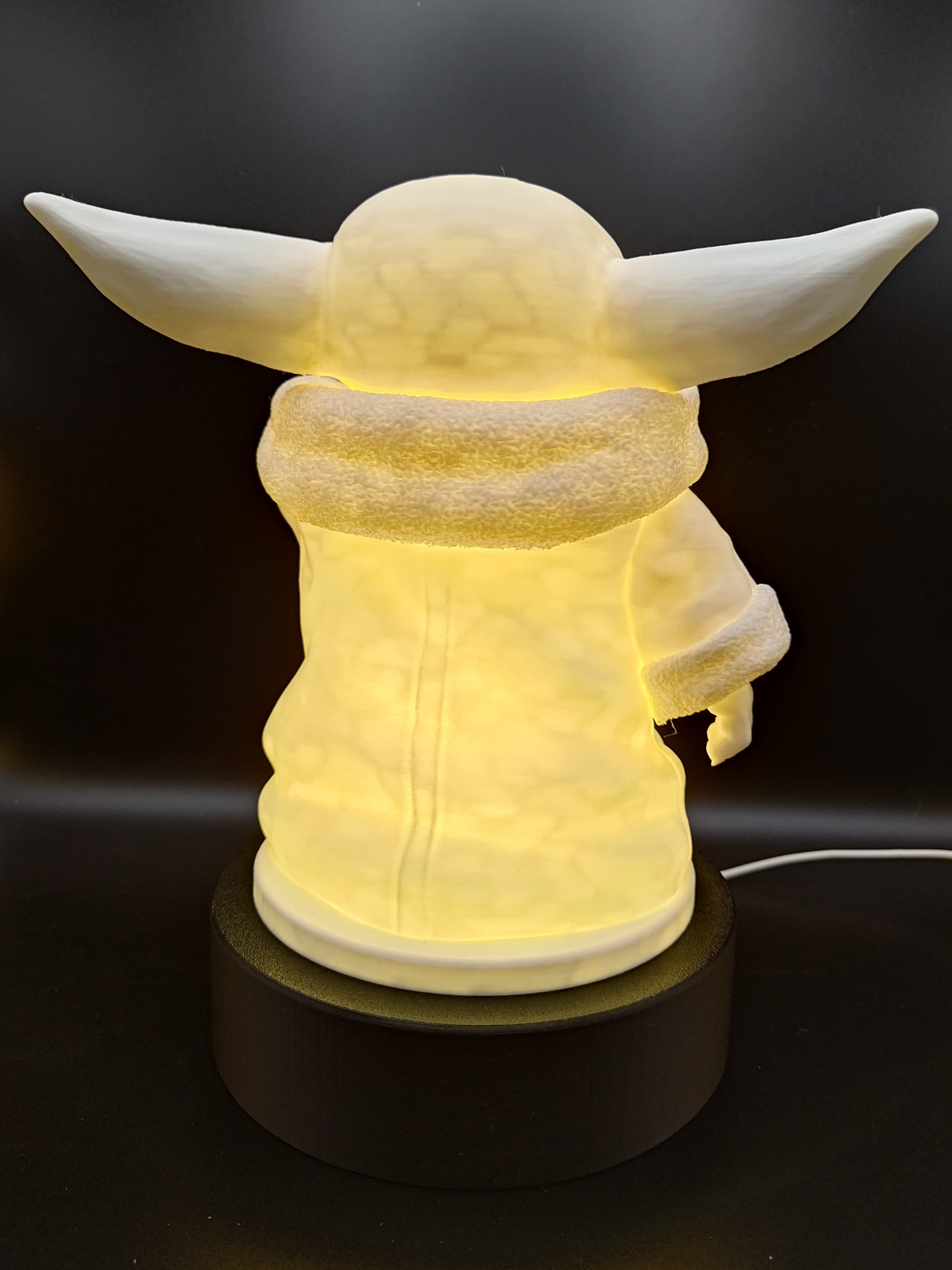 Rear view of the illuminated Grogu lamp showing the wide ears and textured collar