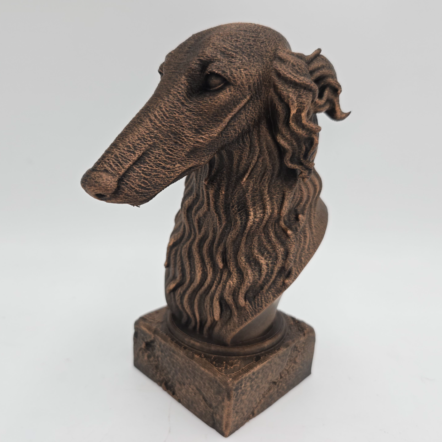 Bronze Borzoi dog bust sculpture viewed from the front left, featuring a long slender muzzle and detailed wavy fur on a decorative pedestal.