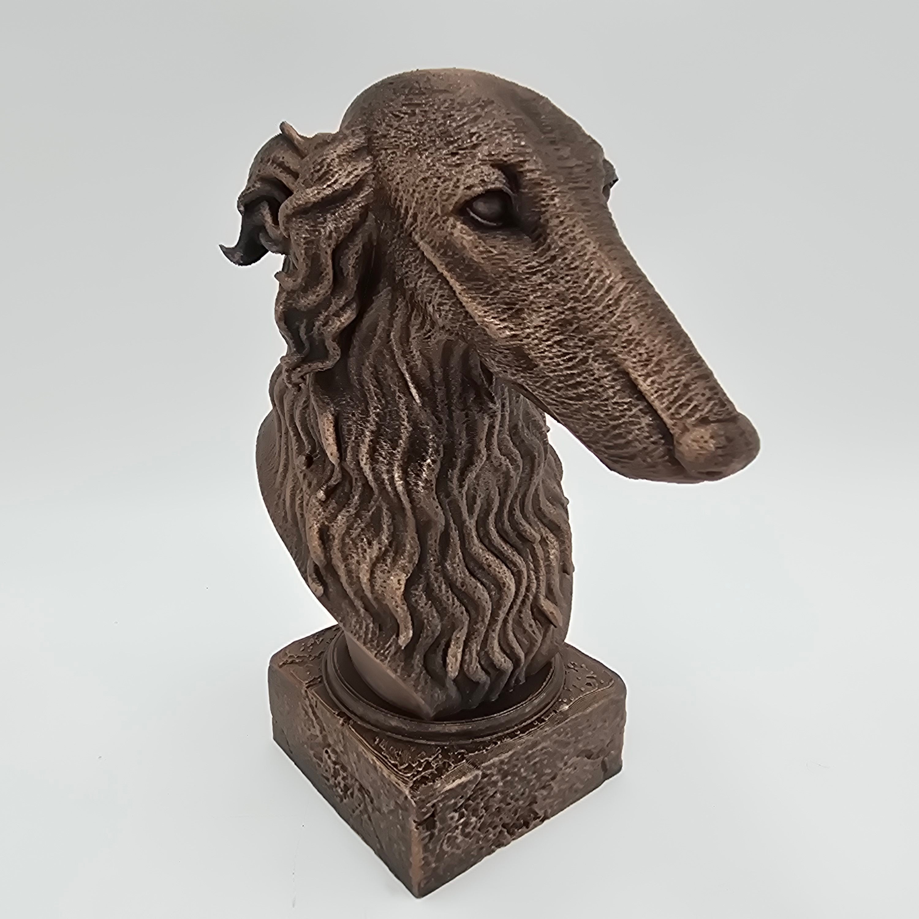 Bronze Borzoi dog bust sculpture viewed from the front right, featuring a long slender muzzle and detailed wavy fur on a decorative pedestal.